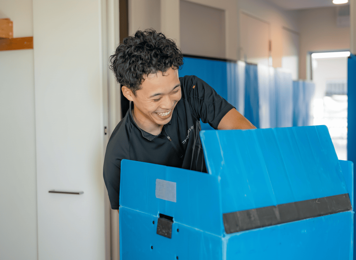養生材で保護した荷物を運ぶスタッフ